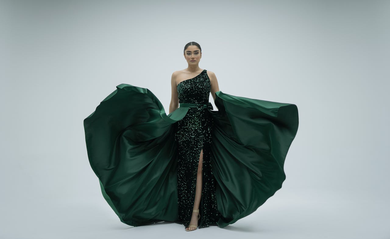 services-01 Elegantly dressed woman poses in a flowing green dress against a white background, exuding fashion and grace.